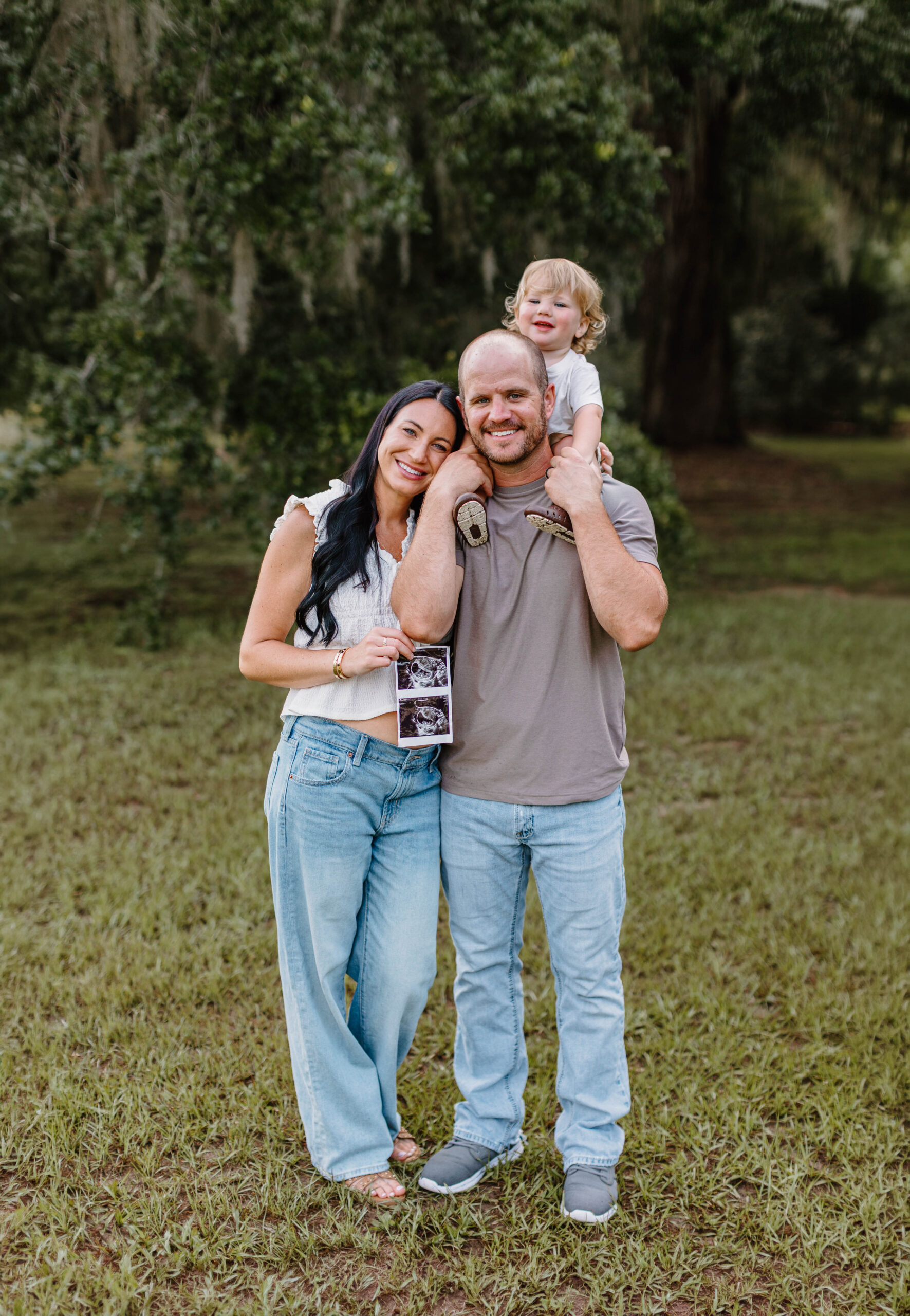 Family in spanish moss trees taking baby announcement photo on Hilton Head Island